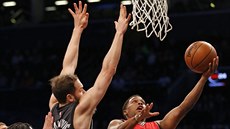 Kyle Lowry (vpravo) z Toronta stílí na ko Brooklynu kolem rukou Bojana...