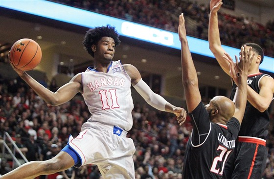 Josh Jackson (11) z Kansasu pihrává v utkání s Texas Tech kolem Anthonyho...