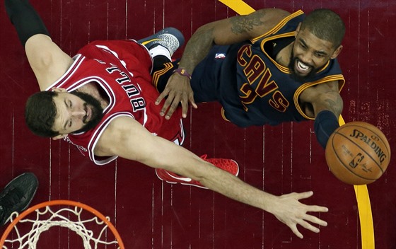 Kyrie Irving (vpravo) z Clevelandu zakonuje na chicagský ko pes ruku Nikoly...