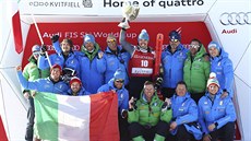 Italský lya Peter Fill slaví se svým týmem triumf v superobím slalomu v...