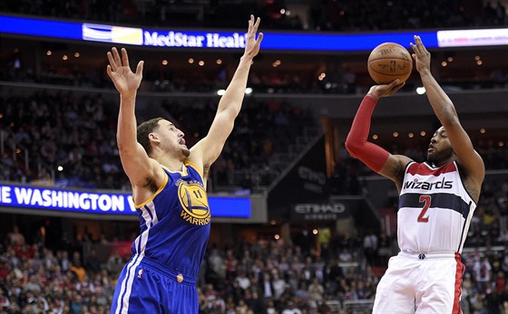 John Wall z Washingtonu pi stelb, brání ho Klay Thompson z Golden State.