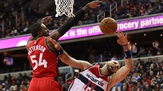 Marcin Gortat (vpravo) z Washingtonu se hroutí pod tlakem Patricka Pattersona z... Marcin Gortat (vpravo) z Washingtonu se hroutí pod tlakem Patricka Pattersona z...