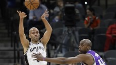 Tony Parker (vlevo) ze San Antonia pihrává, brání ho Anthony Tolliver ze...