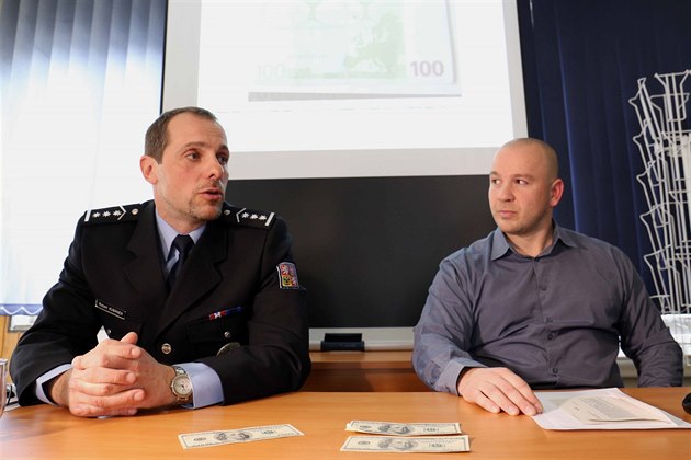Zleva policisté Robert Kubánek a Petr Molnár pedvádjí zadrené falené...
