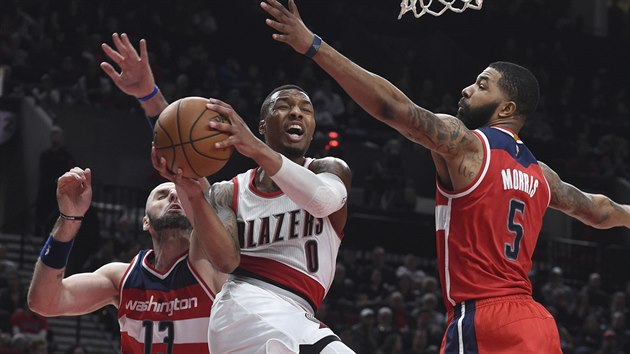 Damian Lillard z Portlandu se pokou dopravit m do koe mezi dvojic Marcin Gortat (vlevo) a Markieff Morris z Washingtonu.