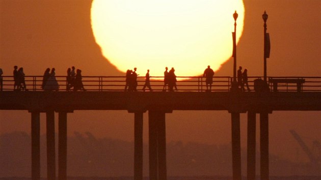 Lid sleduj zpad slunce na molu v kalifornskm Huntington Beach. (29. kvtna 2004)