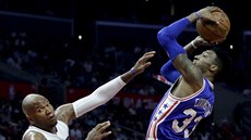 Robert Covington (vpravo) z Philadelphie pi nájezdu kolem Marreeseho Speightse...