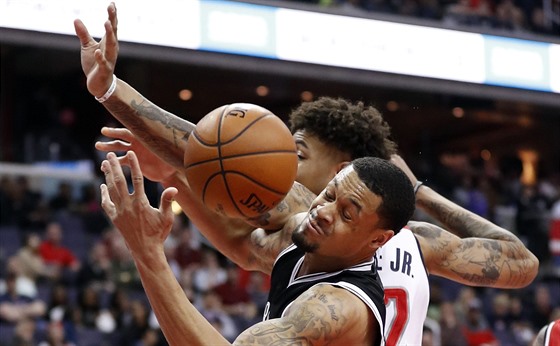 Kelly Oubre Jr. (v bílém) z Washingtonu vyráí mí K. J. McDanielsovi z...