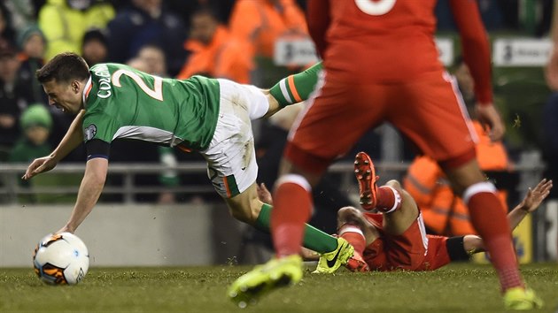 Seamus Coleman z Irska pad po faulu Neila Taylora z Walesu.