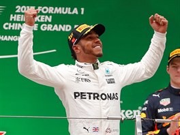JAKO KING KONG. Lewis Hamilton pzuje po triumfu ve Velk cen ny. Hlavu dole...