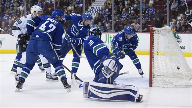 Brank Vancouver Ryan Miller inkasuje gl od Tome Hertla (vlevo v blm) ze San Jose.