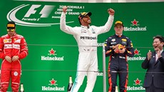 JAKO KING KONG. Lewis Hamilton pózuje po triumfu ve Velké cen íny. Hlavu dole...