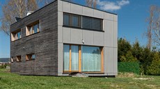 Fasáda domu je z neošetřeného modřínového dřeva a šedivých vláknocementových... Fasáda domu je z neošetřeného modřínového dřeva a šedivých vláknocementových...
