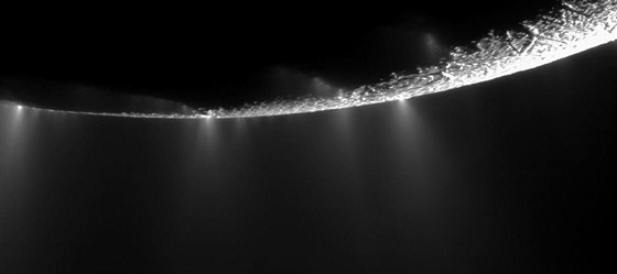 Dramatický pohled na výtrysky vystupující nad povrch Enceladu, jak je vidla...