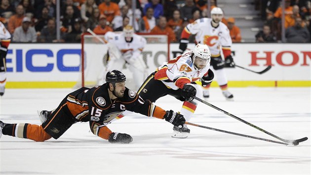 Michael Frolk (vpravo) z Calgary a Ryan Getzlaf z Anaheimu se natahuj po puku.