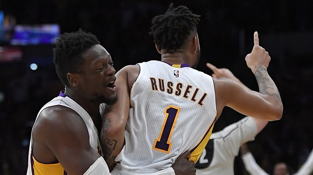 D'Angelo Russell slav se spoluhrem Juliusem Randlem z Los Angeles Lakers svou vtznou stelu proti Minnesot. Vpravo natvan trenr zklamanho celku Tom Thibodeau.