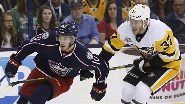 Alexander Wennberg (vlevo) z Columbusu ujd  Carteru Rowneymu z Pittsburghu.