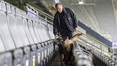 Policista se psem kontrolují tribuny fotbalového stadionu v Dortmundu před... Policista se psem kontrolují tribuny fotbalového stadionu v Dortmundu před...