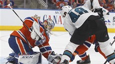 Tomá Hertl ze San Jose ped brankáem Edmontonu Camem Talbotem.