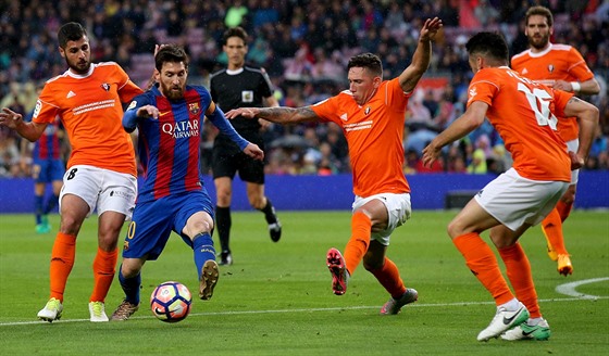 Lionel Messi kolí obranu Osasuny.