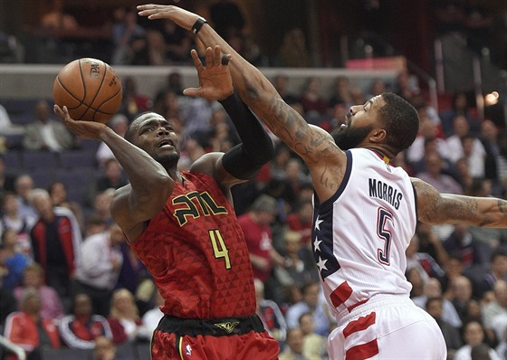 Paul Millsap (vlevo) z Atlanty stílí pes bránícího   Markieffa Morrise z...