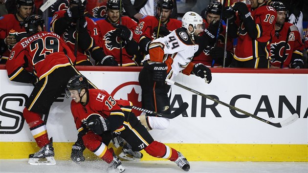 Nate Thompson z Anaheimu prch dvojici Deryk Engelland, Johnny Gaudreau z Calgary.