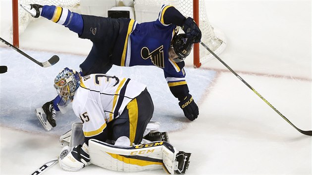 Jaden Schwartz ze St. Louis pad pes branke Pekku Rinneho z Nashvillu.