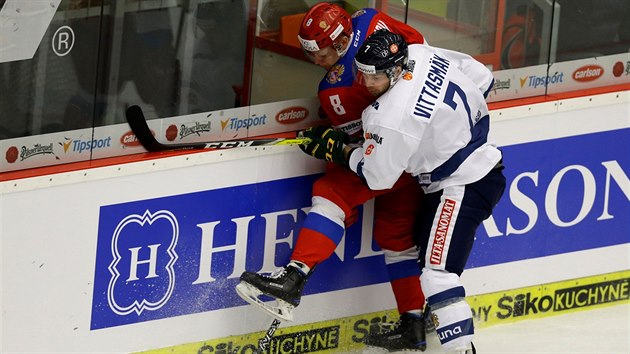 Finsk hokejista Veli-Matti Vittasmki (vpravo) a Andrej Svetlakov z Ruska bojuj u mantinelu.