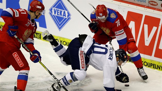 Finsk hokejista Juhamatti Aaltonen (v blm) mezi dvma protihri z Ruska - vlevo je Vadim ipaov, vpravo pak Mikhail Naumenkov.