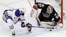 Benoit Pouliot z Edmontonu v anci, branká Anaheimu John Gibson zasahuje.