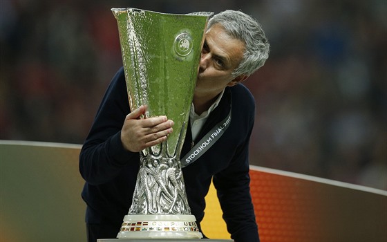 José Mourinho, trenér Manchesteru United, se mazlí s trofejí pro vítze...