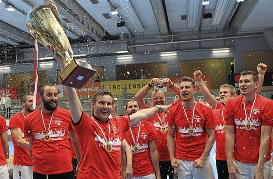 Trenér Petr Hrachovec drí pohár pro ampiona rakouské házenkáské ligy.