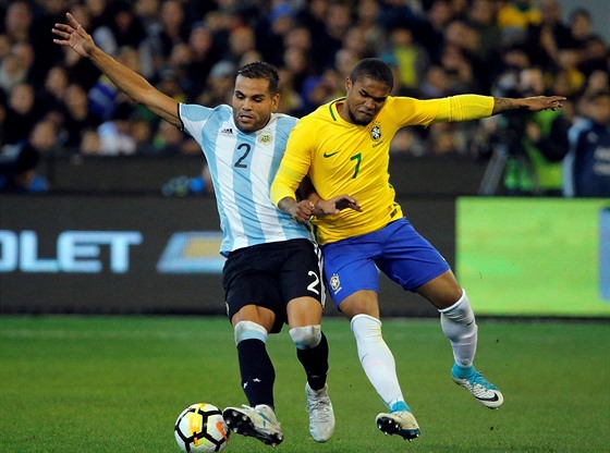 Argentinský fotbalista Gabriel Mercado (vlevo) a  Douglas Costa z Brazílie v...