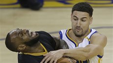 Klay Thompson (vpravo) z Golden State zastavuje LeBrona Jamese z Clevelandu.