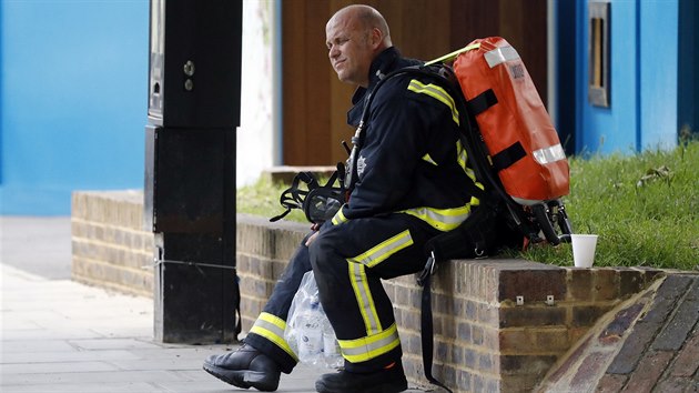 Odpovajc hasi u poru budovy Grenfell Tower v Londn (14.6.2017)