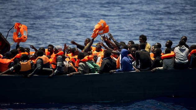 Uprchlci se sna chytit zchrann vesty pi operaci ve Stedozemnm moi nedaleko pobe Libye.