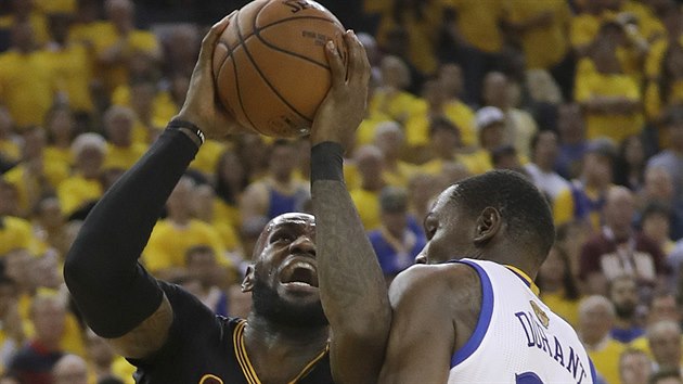 LeBron James (vlevo) z Clevelandu zakonuje kolem Kevina Duranta z Golden State.