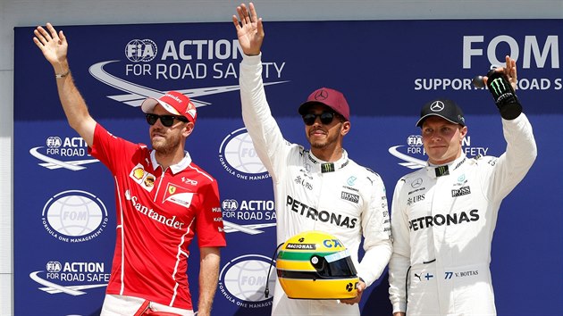 Lewis Hamilton slav triumf v kvalifikaci na Velkou cenu Kanady (uprosted), vlevo je druh Sebastian Vettel a vpravo tet Valtteri Bottas.