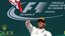 LETÍ VLAJKA. Lewis Hamilton hází divákm britskou vlajku na oslavu vítzství ve...