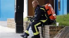 Odpoívající hasi u poáru budovy Grenfell Tower v Londýn (14.6.2017)