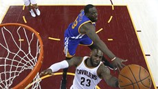 LeBron James (v bílém) z Clevelandu zakonuje po souboji s Draymondem Greenem z...