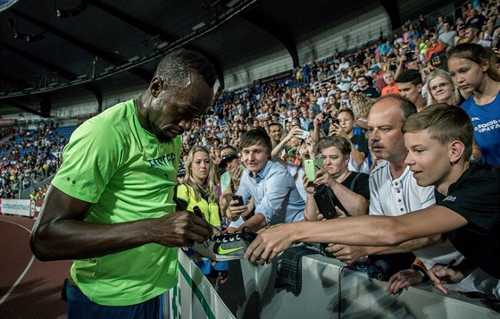 Usain Bolt se podepisuje fanoukm na Zlaté trete.