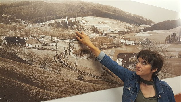 Starostka Eva Tořová ukazuje na velkoformátové historické fotografii, kam až obvykle dosahuje hladina přehrady.
