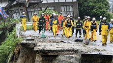 Hasiči pochodují po silnici zničené sesuvy půdy ve městě Asakura na jihozápadě... Hasiči pochodují po silnici zničené sesuvy půdy ve městě Asakura na jihozápadě...