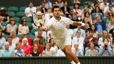 Novak Djokovi se natahuje po míku v utkání s Adrianem Mannarinem.