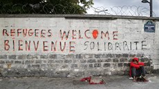 Neznámý běženec sedí nedaleko recepce pařížského přijímacího centra pro... Neznámý běženec sedí nedaleko recepce pařížského přijímacího centra pro...