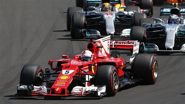 Sebastian Vettel z Ferrari ve Velk cen Maarska formule 1, za nm se tla piloti Mercedesu Valtteri Bottas s Lewisem Hamiltonem.