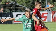 Hlučínský záložník Martin Foltýn (vlevo) se snaží dostat k míči přes... Hlučínský záložník Martin Foltýn (vlevo) se snaží dostat k míči přes...