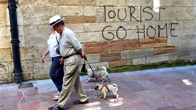 Lidé procházejí kolem protituristického graffiti v historickém centru... Lidé procházejí kolem protituristického graffiti v historickém centru...