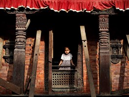 KRÁLOVSKÝ VÝHLED. Mladá nepálská dívka se dívá z okna chrámu na námstí...